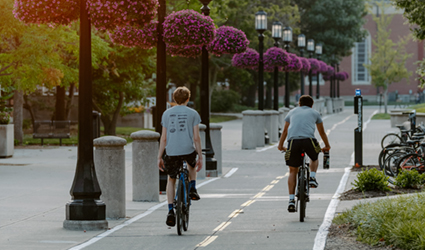 2 men biking along Purdue biking path on campus