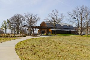 Beck Barn, a large historic barn recently restored and modernized, surrounded by bare autumn trees in fall.