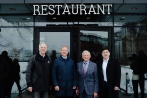 A group of four men pose in front of The Lawrence restaurant.